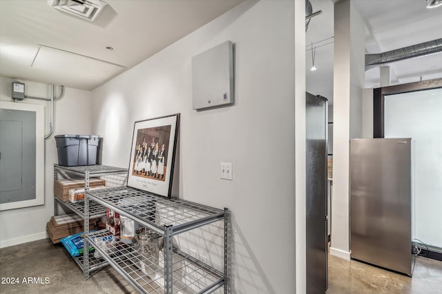 hall with electric panel and concrete floors