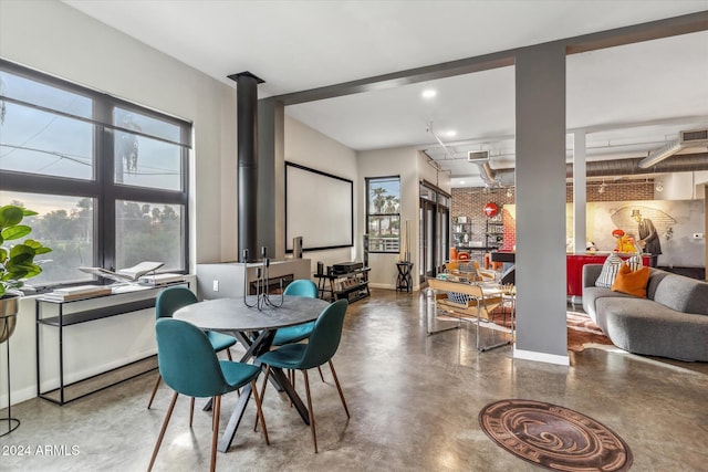 dining room featuring concrete floors and brick wall