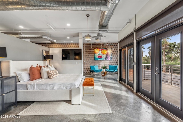 bedroom with brick wall, concrete floors, french doors, and access to exterior