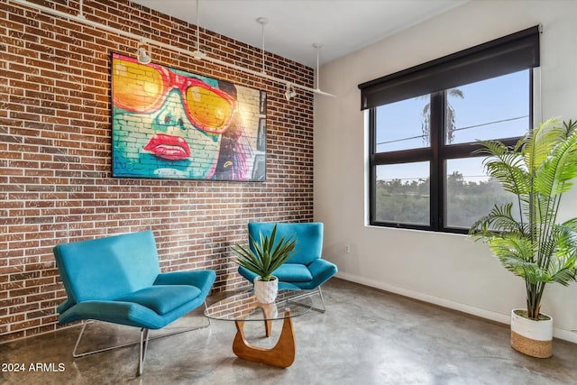 sitting room with concrete floors and brick wall