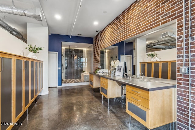 kitchen featuring brick wall and light brown cabinets