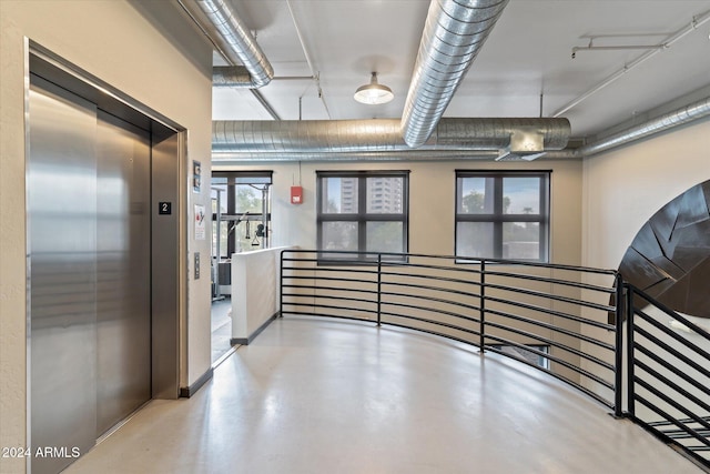 hall with elevator and concrete floors