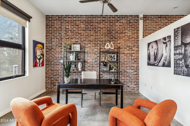 office space with ceiling fan, concrete floors, and brick wall