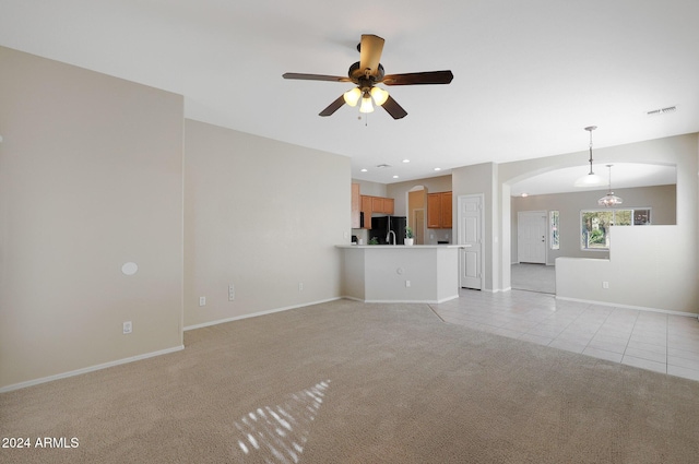 unfurnished living room with light carpet and ceiling fan