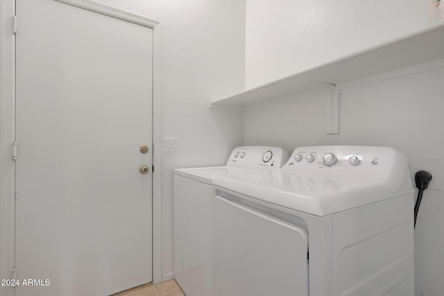 washroom featuring washer and clothes dryer and light tile patterned flooring