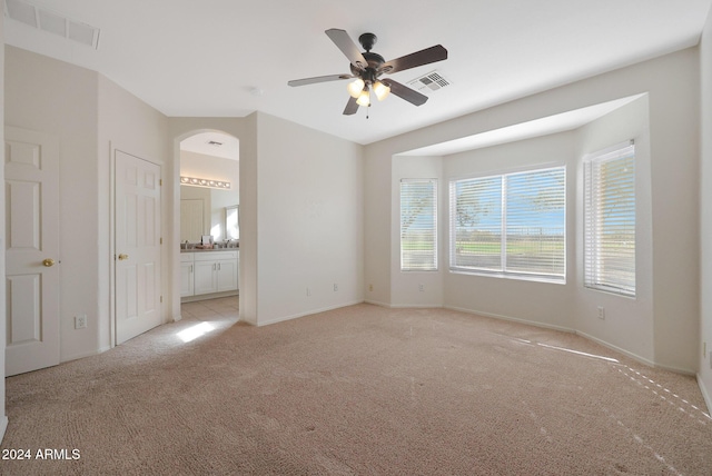 carpeted spare room with ceiling fan