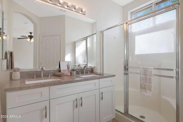 bathroom with ceiling fan, vanity, and walk in shower