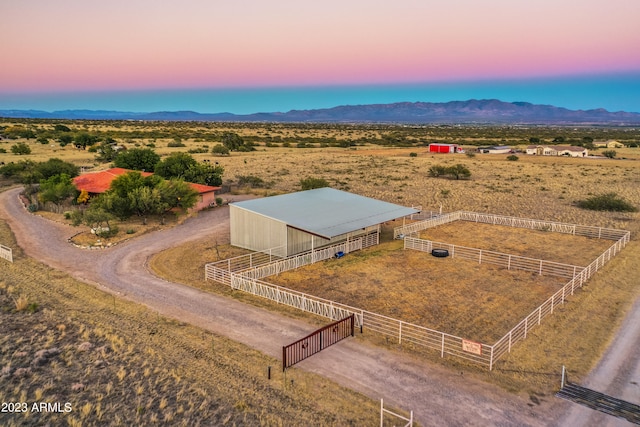 aerial view at dusk with a mountain view and a rural view