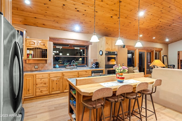 kitchen with backsplash, pendant lighting, appliances with stainless steel finishes, and sink