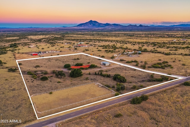 aerial view at dusk with a mountain view and a rural view