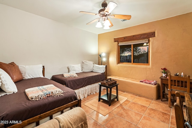 tiled bedroom featuring ceiling fan