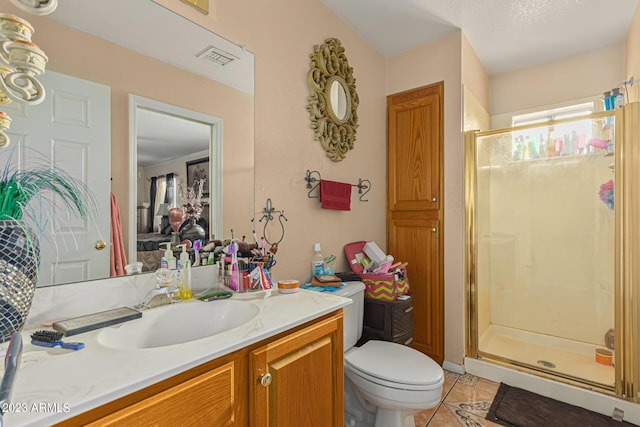 bathroom featuring tile patterned flooring, vanity, toilet, and walk in shower