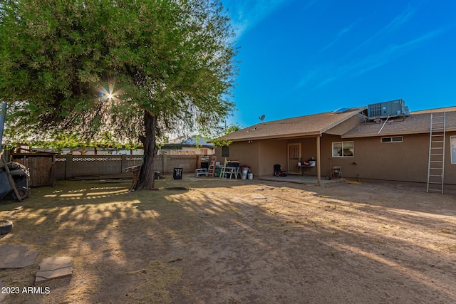 back of property with central AC and a patio area