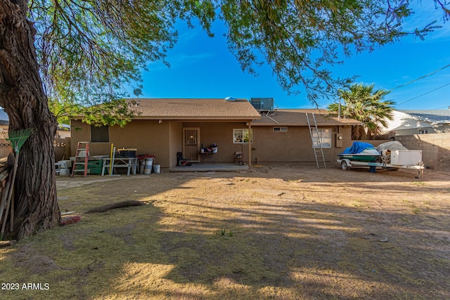 rear view of property featuring cooling unit, a yard, and a patio