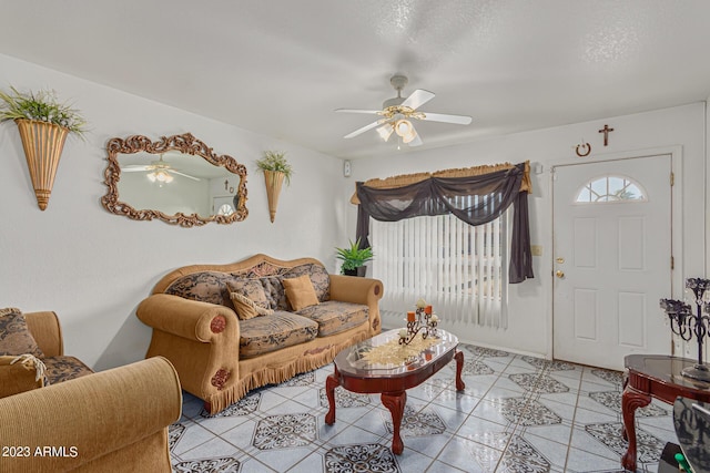 tiled living room with a textured ceiling and ceiling fan