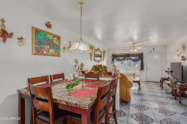 tiled dining room featuring ceiling fan and a textured ceiling