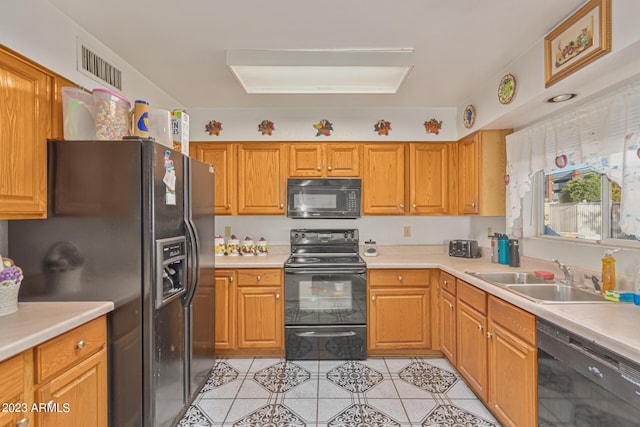 kitchen featuring light tile patterned flooring, sink, and black appliances