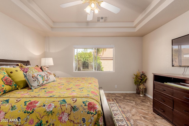 bedroom featuring ceiling fan and a raised ceiling