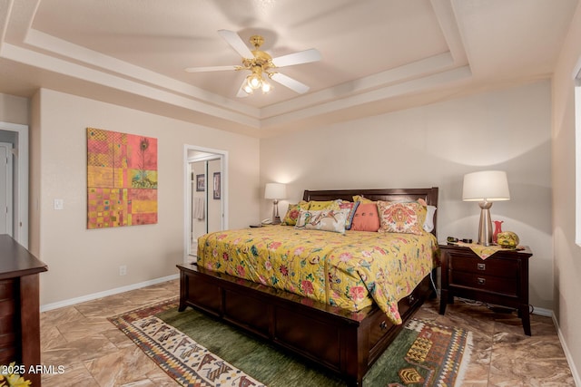 bedroom featuring a raised ceiling and ceiling fan