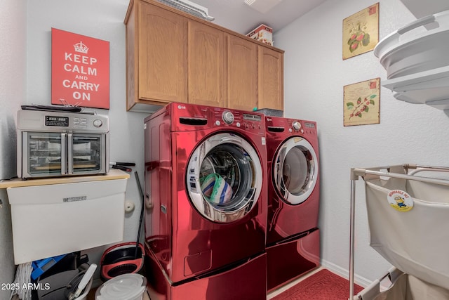 clothes washing area with cabinets and washer and dryer