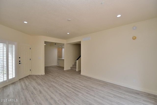 interior space with light hardwood / wood-style flooring and a textured ceiling