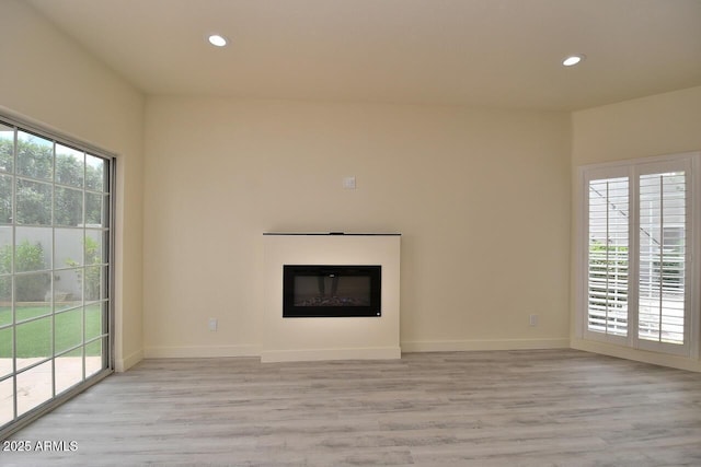 unfurnished living room featuring a healthy amount of sunlight and light hardwood / wood-style floors