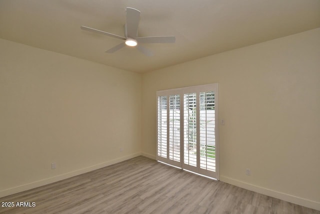 empty room with ceiling fan and light hardwood / wood-style flooring