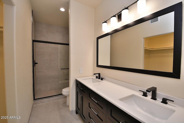 bathroom featuring vanity, a shower with shower door, tile patterned floors, and toilet