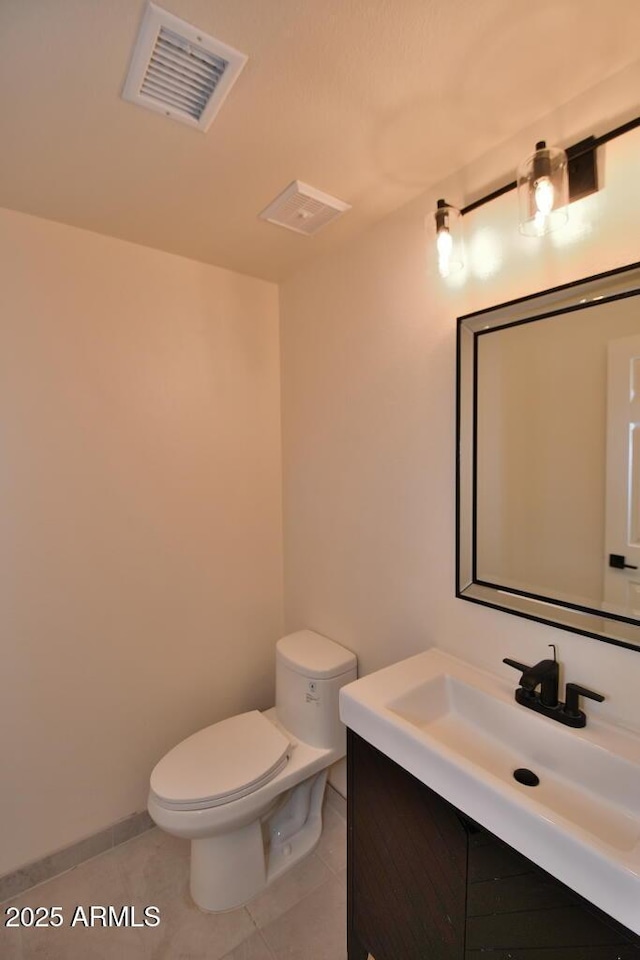 bathroom featuring vanity, tile patterned floors, and toilet