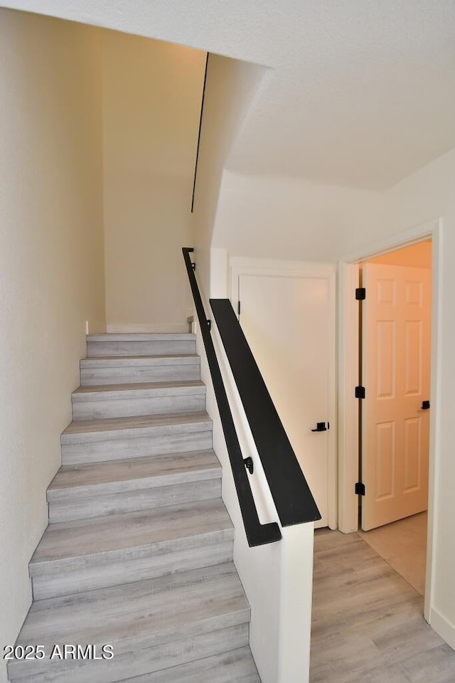 stairway featuring wood-type flooring