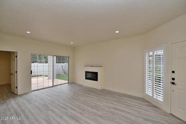 unfurnished living room featuring light hardwood / wood-style flooring and a wealth of natural light