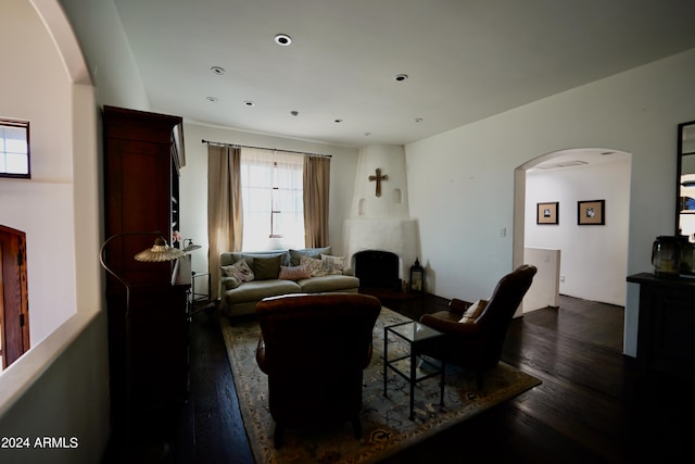 living room with a large fireplace and dark hardwood / wood-style floors