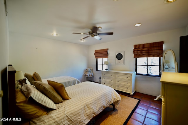 tiled bedroom featuring multiple windows and ceiling fan