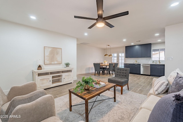 living room with a ceiling fan, recessed lighting, and light wood-style floors