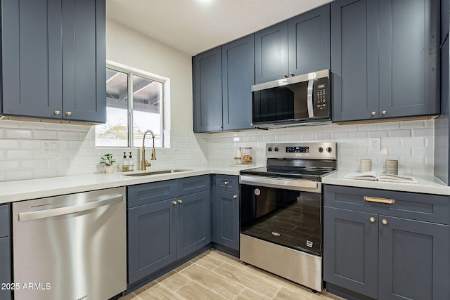 kitchen with light countertops, appliances with stainless steel finishes, and a sink