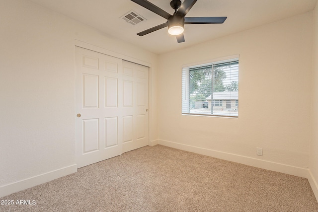 unfurnished bedroom featuring light colored carpet, visible vents, a closet, and baseboards