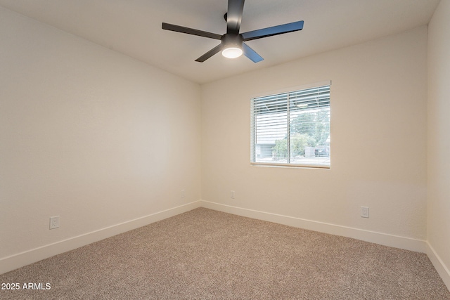 carpeted empty room with a ceiling fan and baseboards