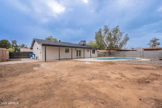 rear view of property with a patio, a fenced in pool, a fenced backyard, french doors, and central air condition unit