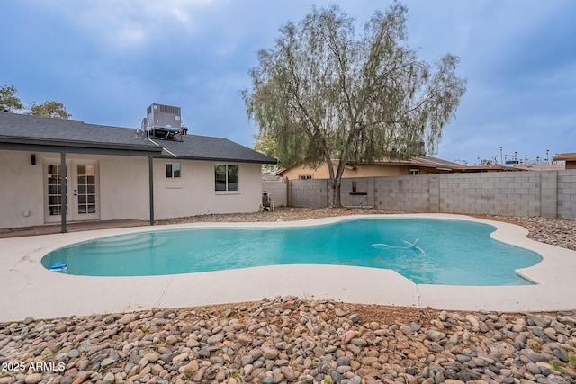 view of pool featuring central air condition unit, a fenced backyard, french doors, a fenced in pool, and a patio area