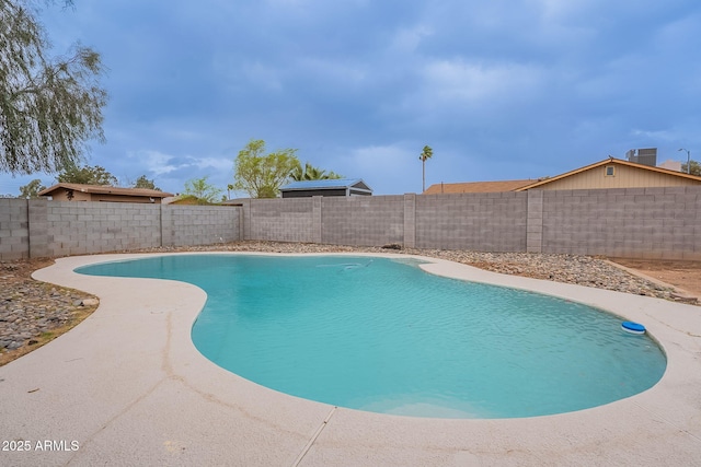 view of pool with cooling unit and a fenced backyard