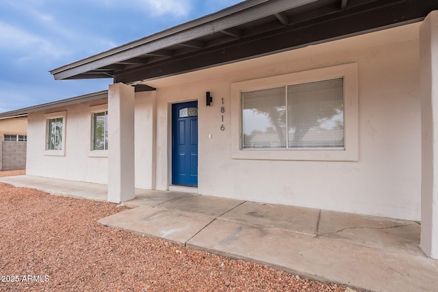 entrance to property featuring stucco siding