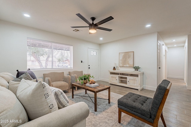 living area featuring visible vents, baseboards, ceiling fan, light wood-type flooring, and recessed lighting