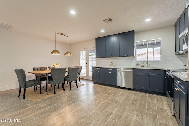 kitchen with tasteful backsplash, visible vents, appliances with stainless steel finishes, and a sink