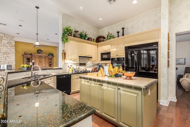 kitchen featuring a center island, sink, hanging light fixtures, kitchen peninsula, and black appliances