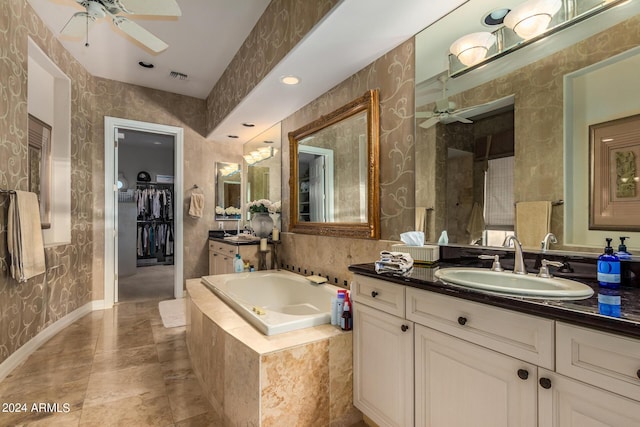 bathroom featuring vanity, ceiling fan, and tiled bath