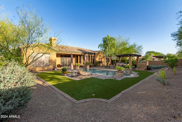 rear view of property with a yard, a pergola, a patio, and a pool with hot tub