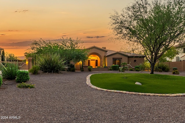 mediterranean / spanish house featuring a lawn