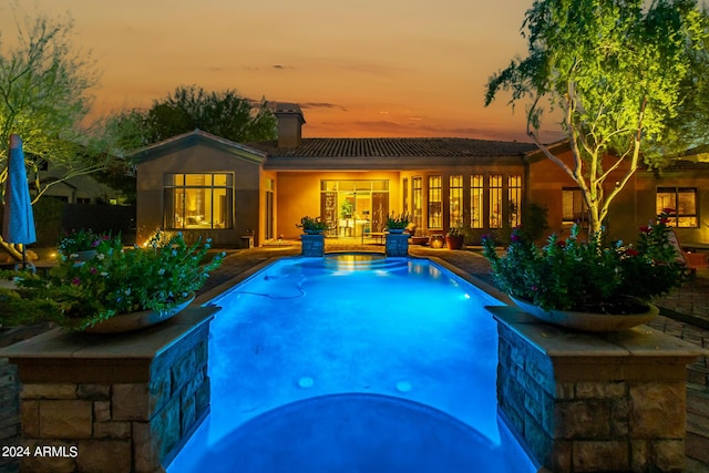 pool at dusk with a patio