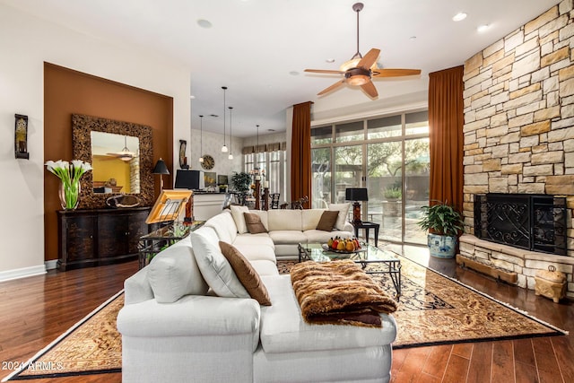 living room with a fireplace, ceiling fan, and dark hardwood / wood-style flooring