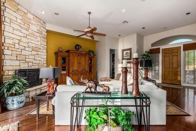 living room with a fireplace, dark hardwood / wood-style flooring, and ceiling fan